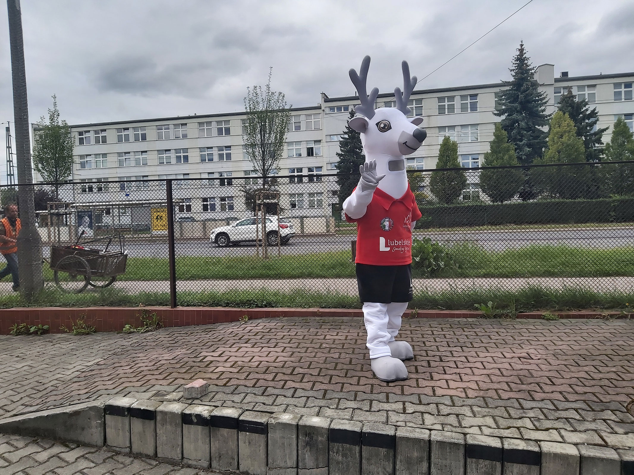 Na fotografii widnieje kostium reklamowy w postaci jelenia pozujący do zdjęcia przed siedzibą firmy Elabika